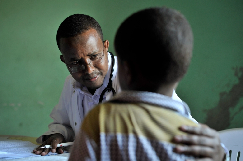 doctor speaks young boy examining